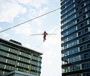 Funambule sur un fil entre deux immeubles